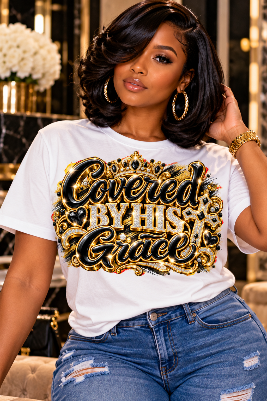 Covered by His Grace design in black and gold on a white T-shirt, seated