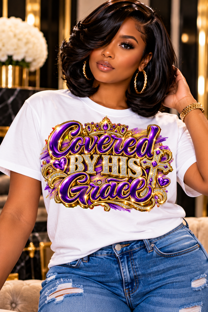 Covered by His Grace design in purple and gold on a white T-shirt, seated
