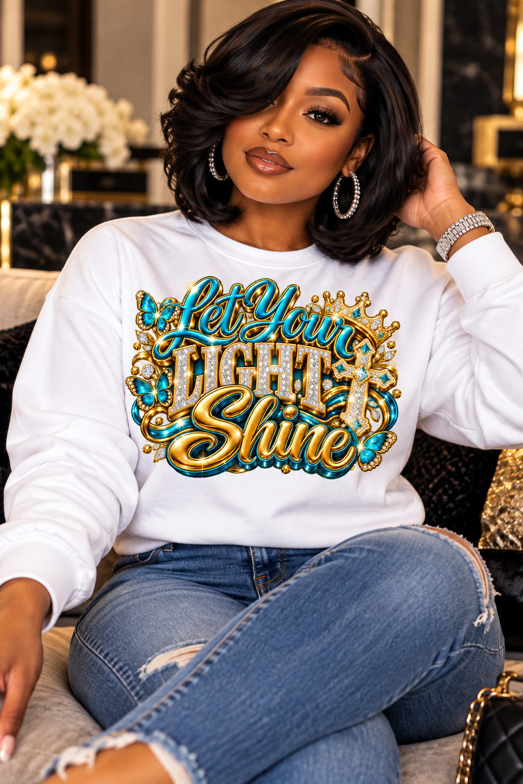 Let Your Light Shine design in turquoise and gold on a white sweatshirt, seated